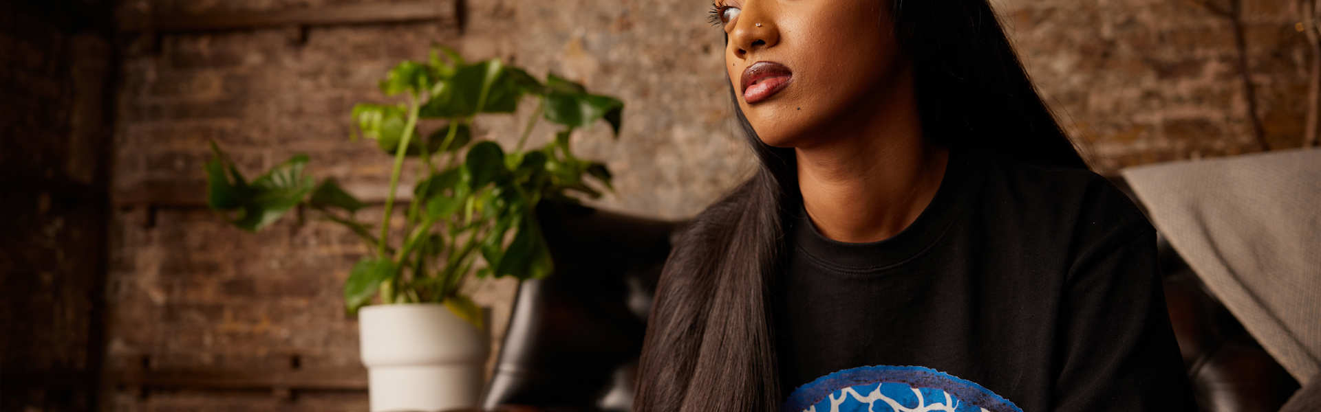 A person thinking, sat on the sofa.