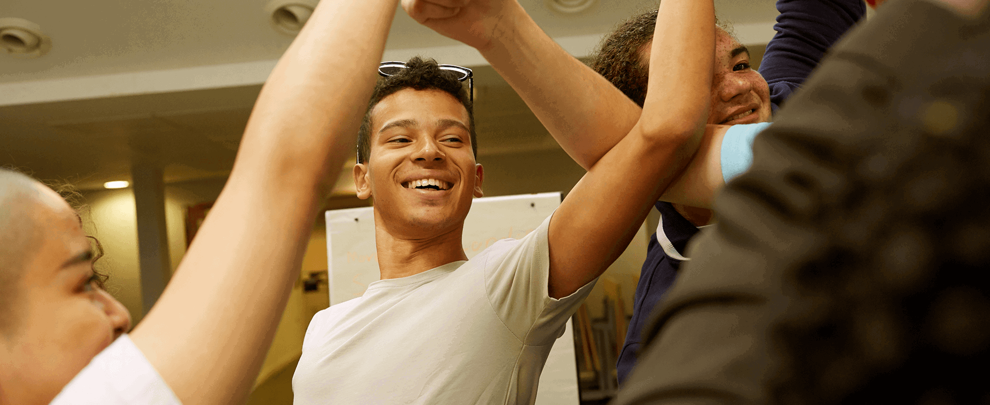 Four young people laughing and playing a game together.