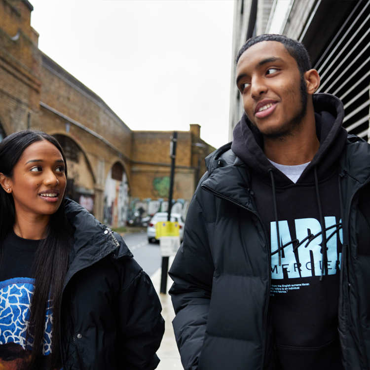 Two people walking and talking on the street.