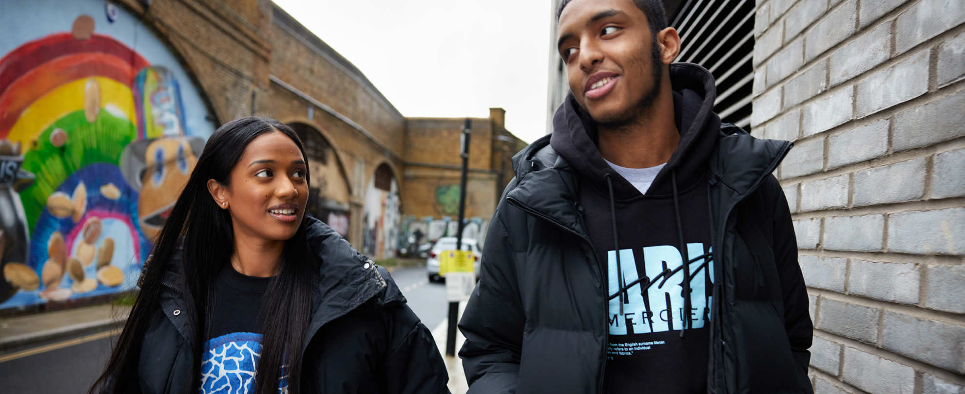Two people walking and talking on the street.