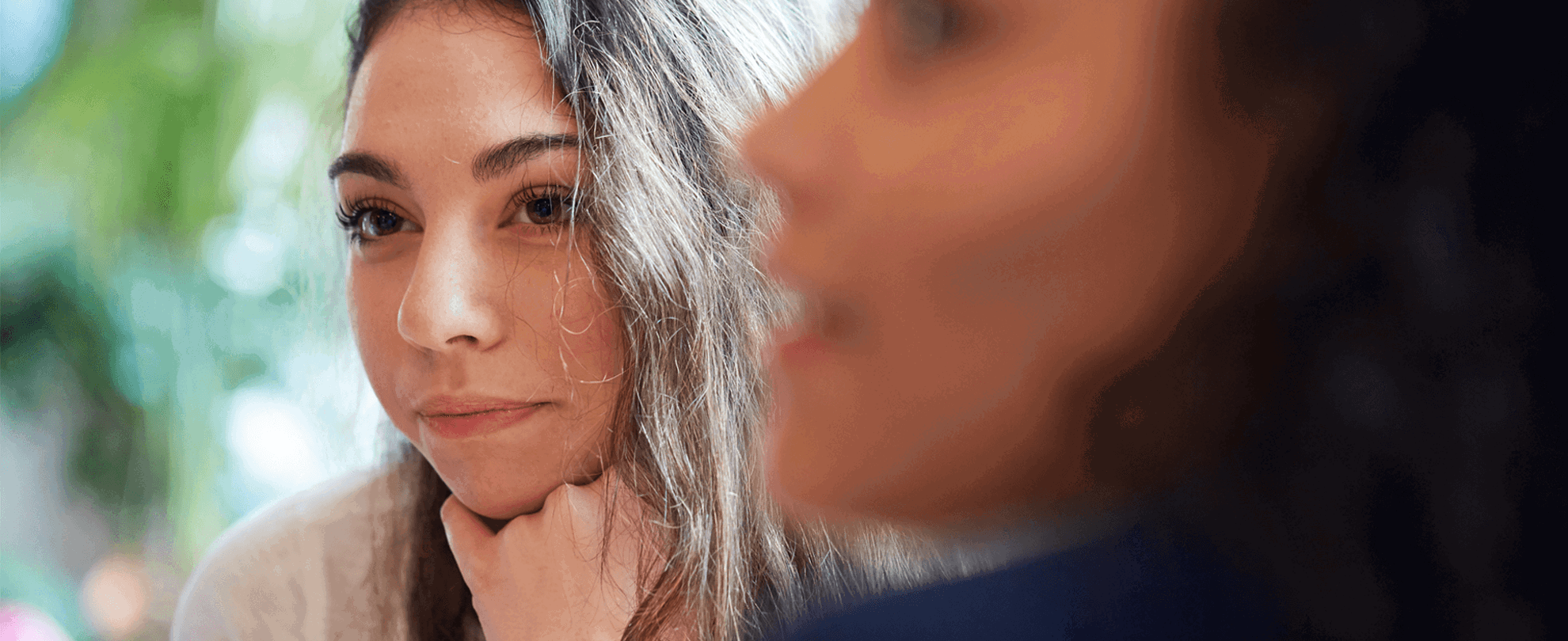 Two young people sitting together and listening to a conversation.
