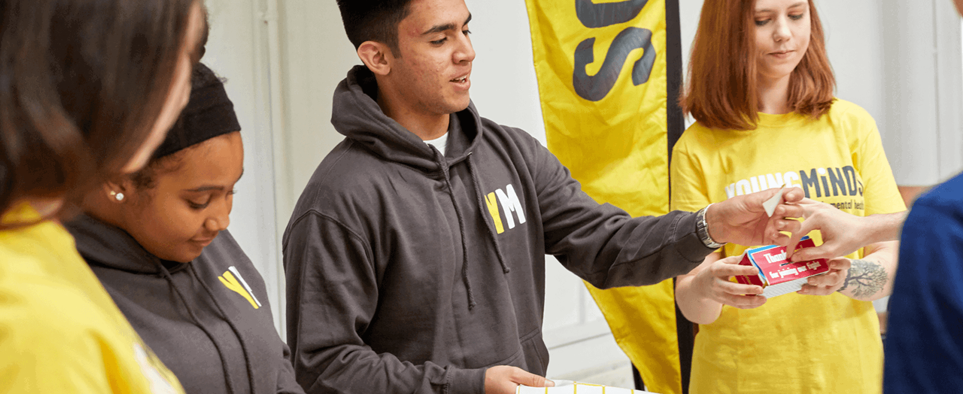 mixed group of YoungMinds volunteer giving out fundraising materials