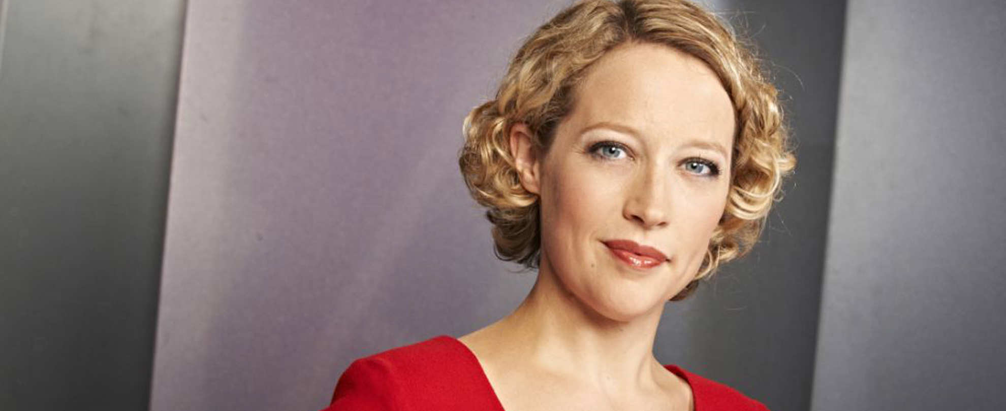 Journalist Cathy Newman in a red top in front of a grey background