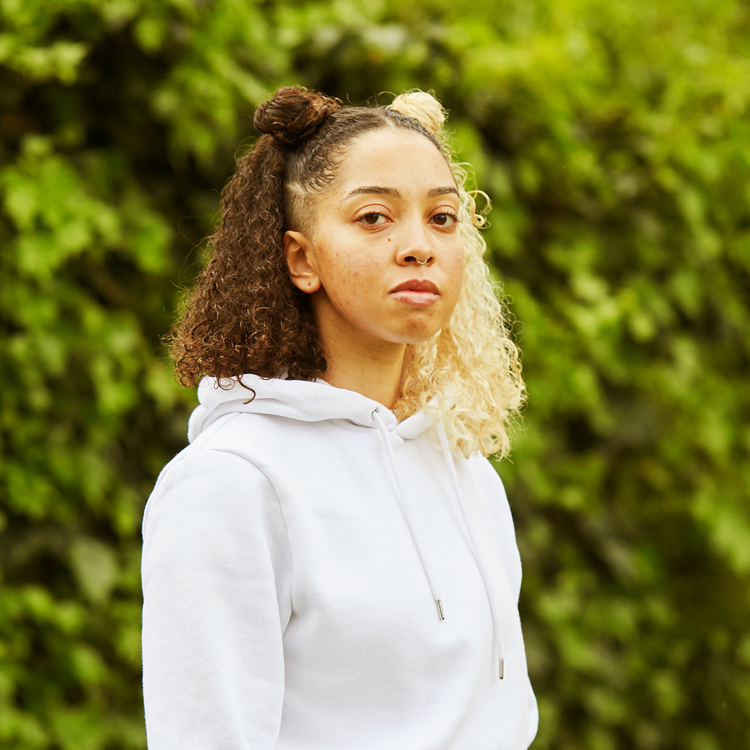 A girl starting at the camera in the park.