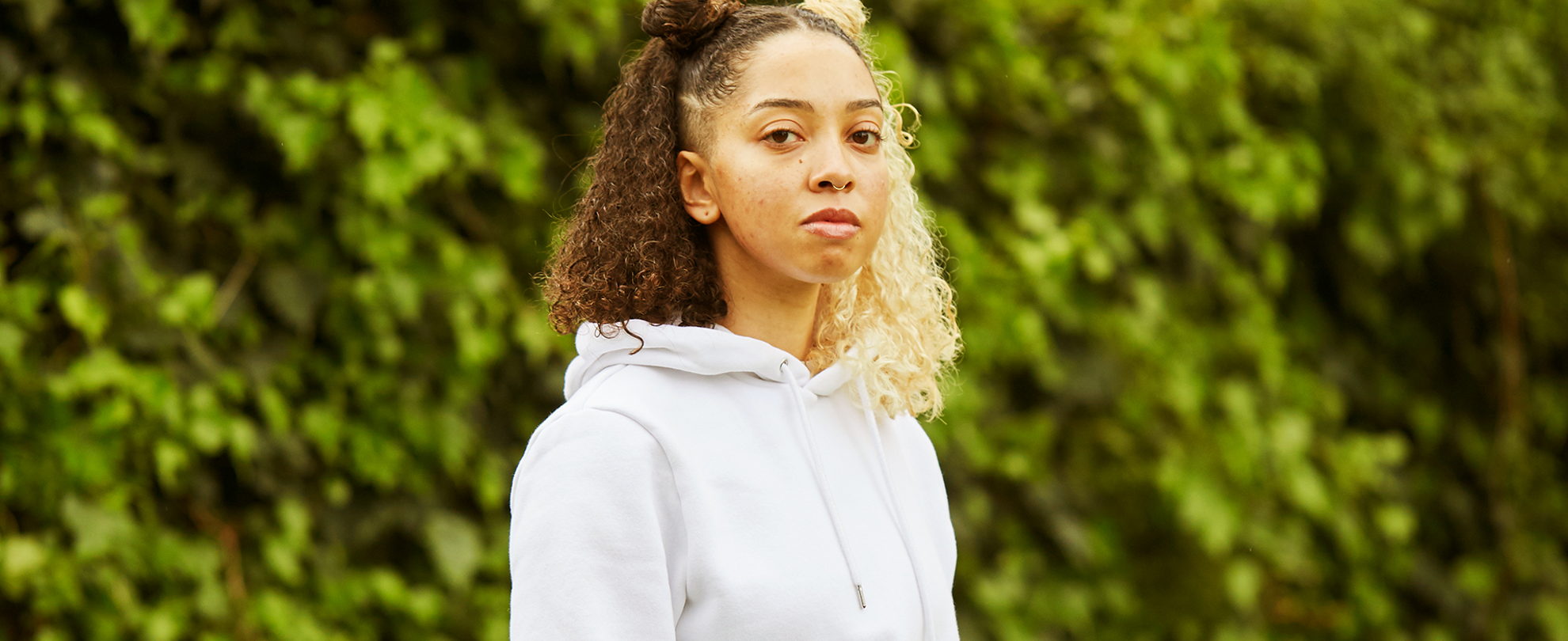 A girl starting at the camera in the park.