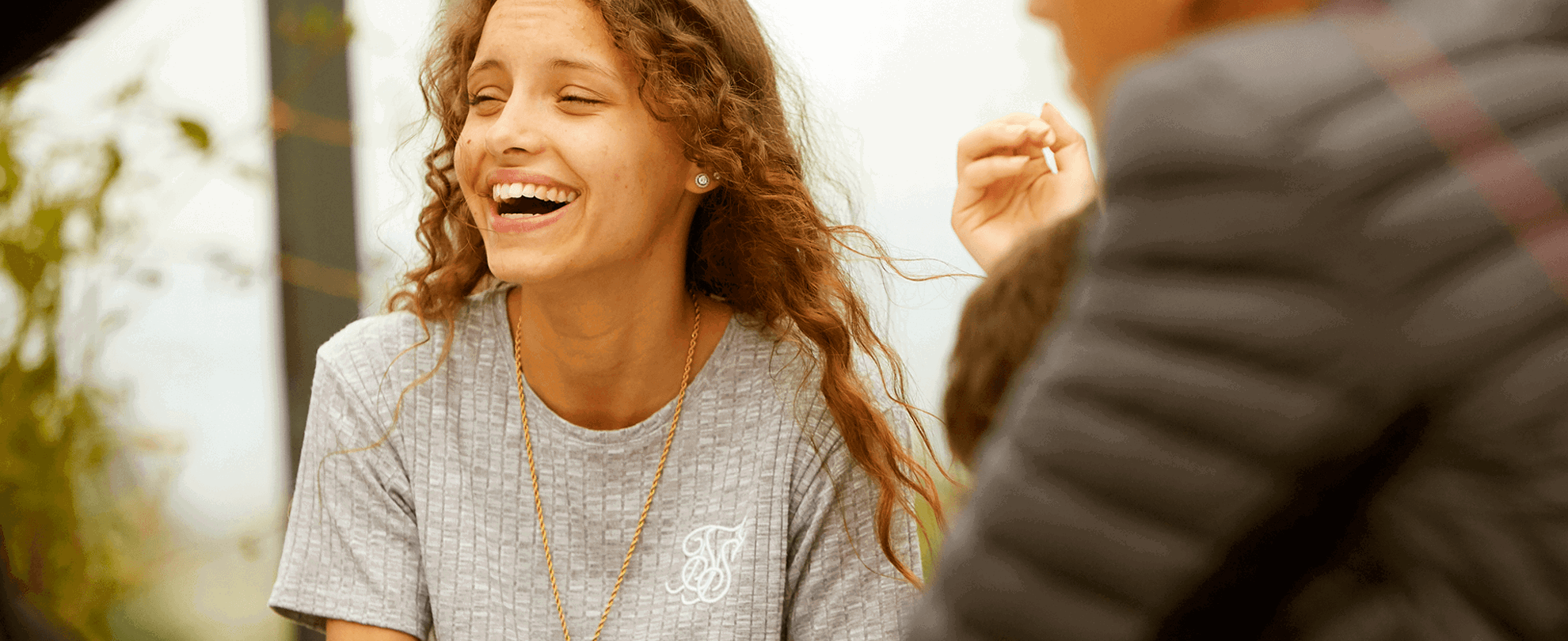 A young person laughing with her friends.