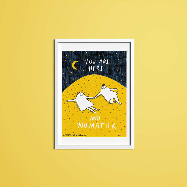 A print by Rubyetc in a white frame with a yellow wall. The print has a night sky at the top with a crescent moon and stars. In the night sky the text reads: you are here. Underneath is a big yellow hill with two people lying on top of the grass. The people are looking at each other and smiling. Underneath the people the text reads: and you matter. In the bottom right hand corner it reads: Rubyetc for YoungMinds.