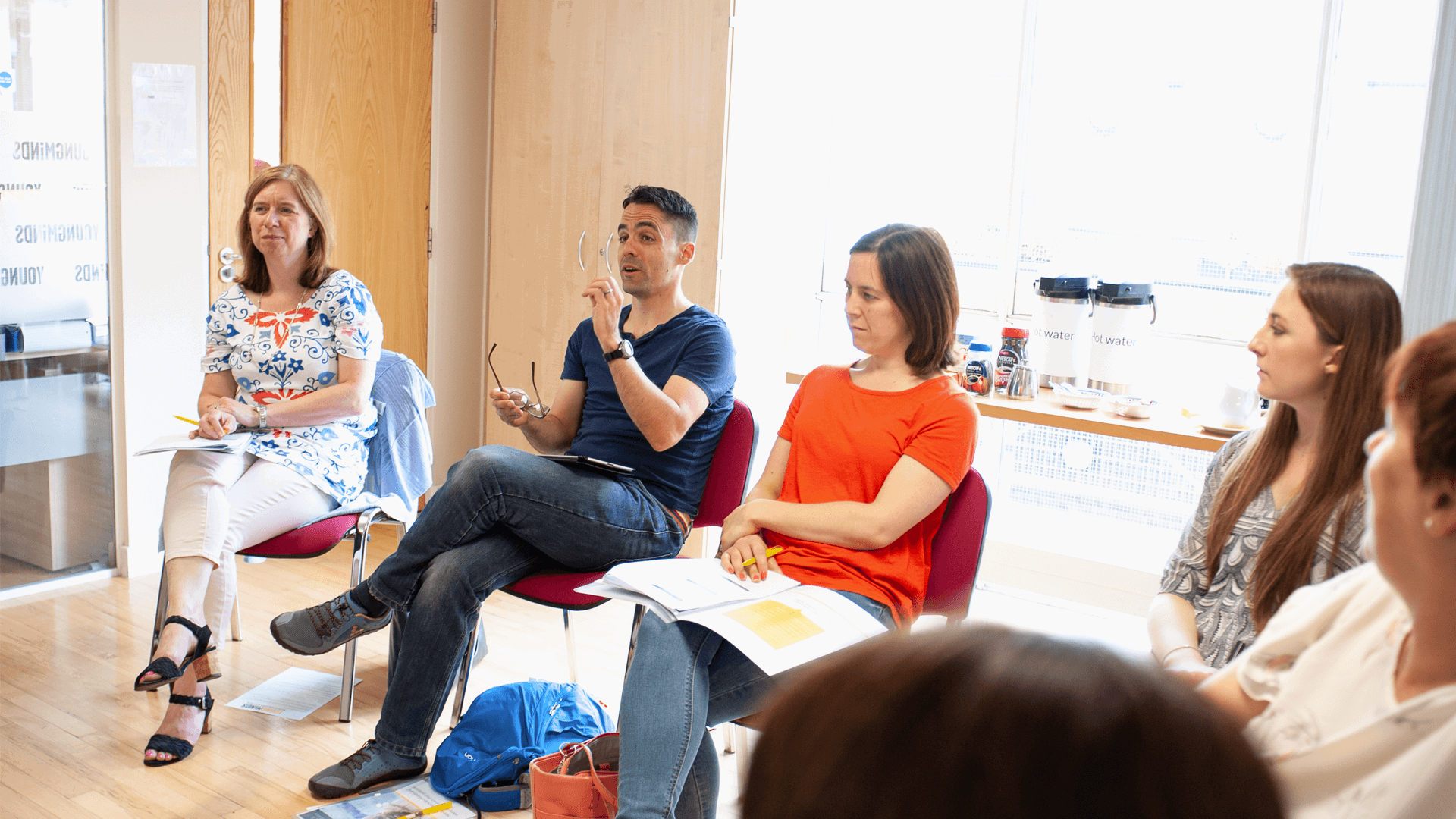 A room full of parents having a discussion in the classroom