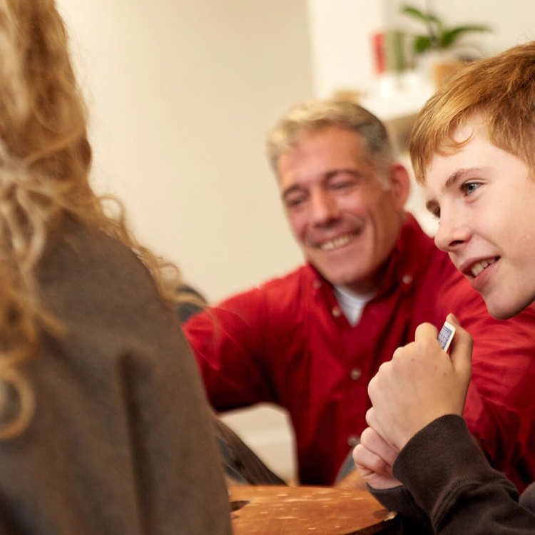 A boy and his parents smiling during a family meeting