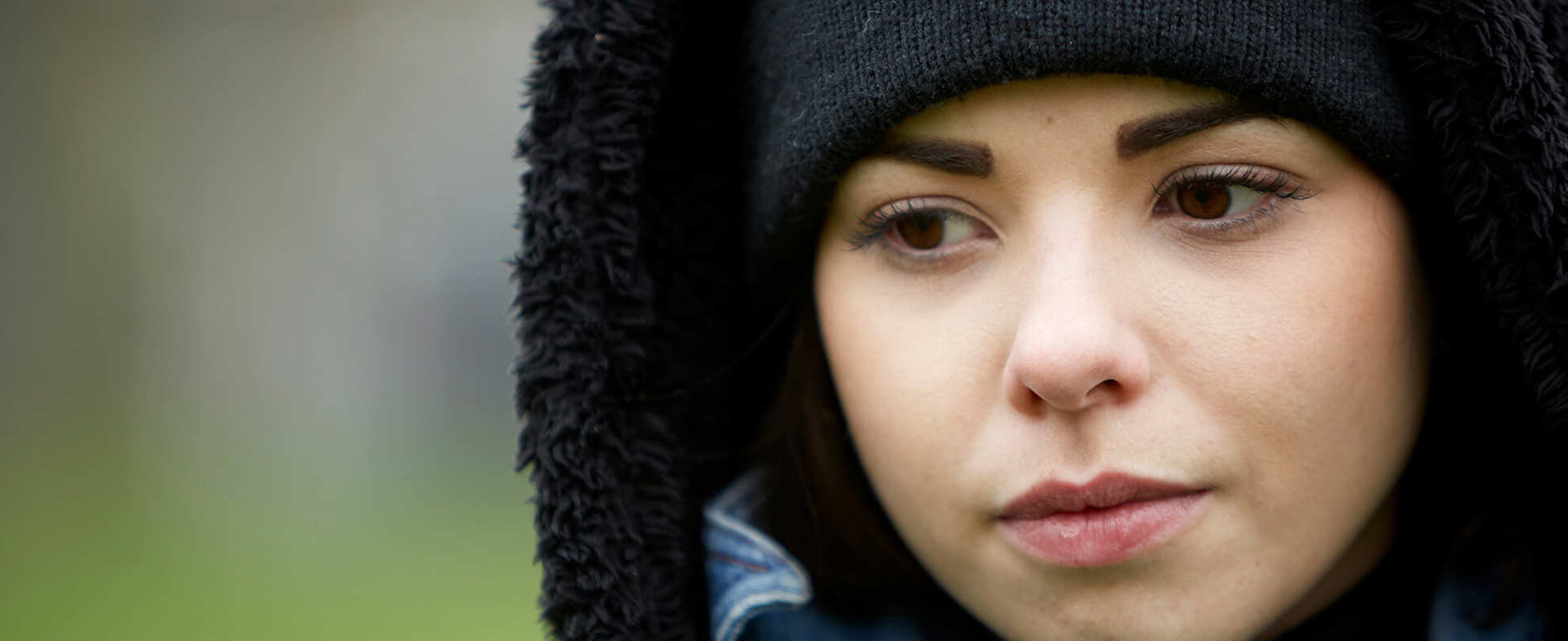 close-up-of-a-girl-wearing-black-beanie-looking-worried-with-eyes-looking-down