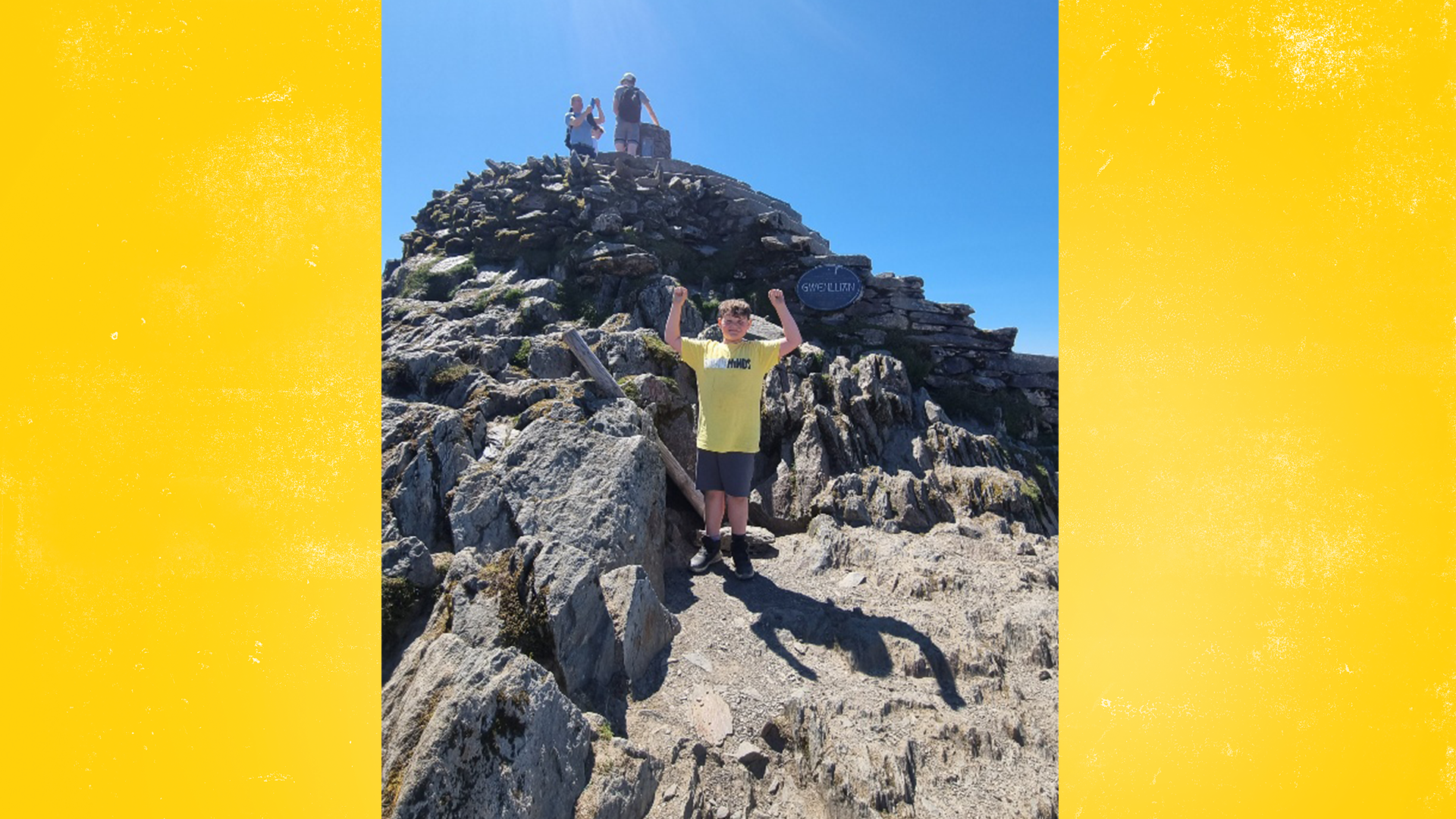 Flynn with his arms in the air at the top of Snowdon.